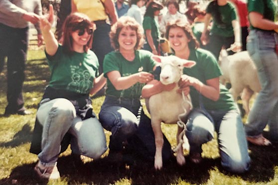 Three students holding a sheep.