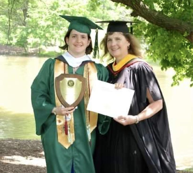 A graduate and a professor in graduaation regalia.