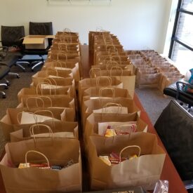 Rows of care package bags lined up ready for distribution.